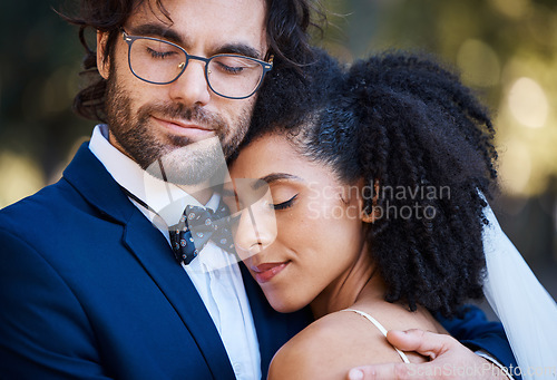 Image of Interracial couple, wedding and hug for love at marriage celebration event with commitment. Happy married man and woman together with trust, partnership and support or care with safety and security