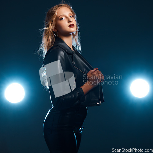 Image of Leather, dance performance and woman portrait of isolated dancer or singer with stage lights. Dark background, studio and theatre presentation of a young female ready for creative dancing with light
