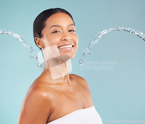 Image of Black woman, portrait and skincare with water splash, blue background and cleaning cosmetics in studio. Face of female model, body shower and beauty for healthy skincare, happy wellness or aesthetics