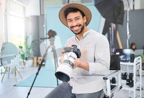 Image of Portrait, photographer and man with camera in studio, happy and smile before a photo shoot. Face, photography and asian guy relax during professional, shooting for model, design and creative career