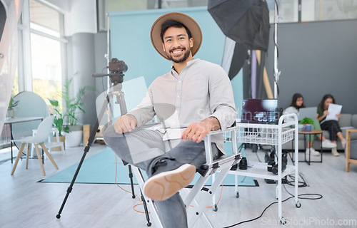 Image of Portrait, happy and photographer in studio for photo shoot, relax and confident in professional setup. Face, asian male and magazine photography, backstage and proud while posing, smile and casual