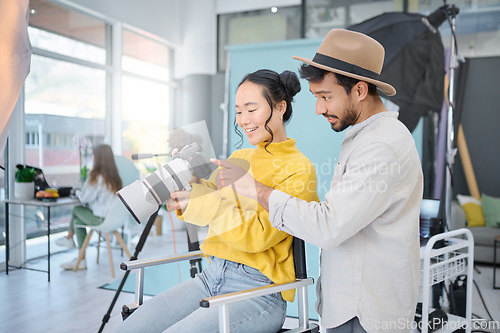 Image of Photography, creative and man talking to a model to choose a image on the camera from the photoshoot. Creativity, art and male photographer speaking to a woman for the best picture in artistic studio