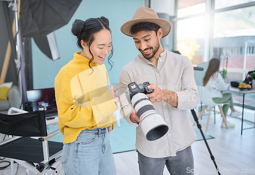 Image of Camera, creativity and photographer talking to a model while looking at pictures from a photoshoot. Photography, creative and young cameraman choosing a image with a woman in creative artistic studio