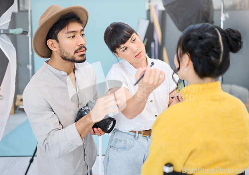 Image of Makeup, artist and woman with photographer and model in studio for artistic, process and photo shoot. Man, photographer and girl coworking on makeover, glamour and beauty during backstage session