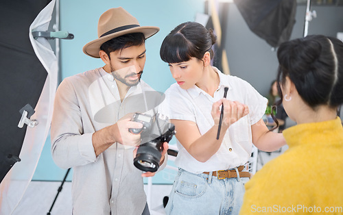Image of Makeup artist, photographer and model checking pictures during artistic, process and glamour shooting in studio. Man, photography and lady coworking on creative, project and magazine cover together