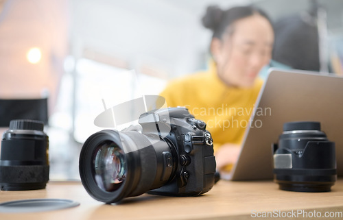 Image of Photography camera, laptop and photographer editing photoshoot, focus on digital art or retouching artistic photo. Studio, creative vision and professional Asian woman working on creativity process