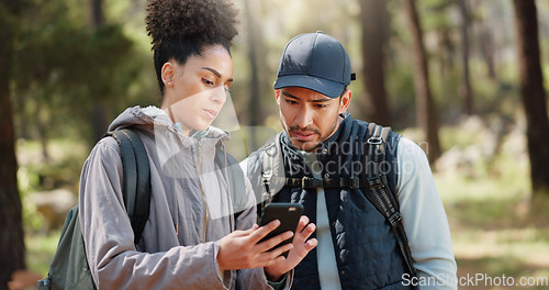 Image of Hiking, smartphone and travel couple with location search, online travel guide or nature journey planning together in a forest on 5g network. Backpack trekking people using phone mobile app in woods