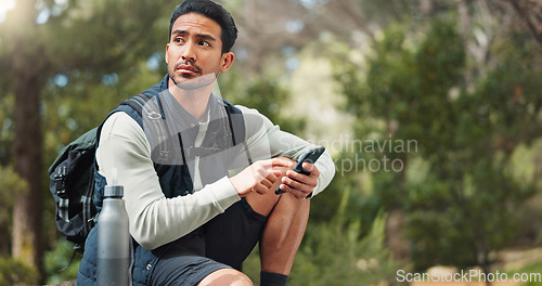 Image of Nature hiking man, typing phone and sitting on rock for rest, break or relax with backpack outdoor. Forest adventure, woods explorer and smartphone for coordinate direction on gps navigation by trees