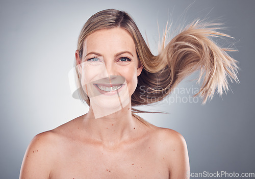 Image of Woman in portrait, smile and face with hair in air, beauty and keratin treatment, cosmetic care isolated on studio background. Happy model, glow and hairstyle shine, natural cosmetics and skincare