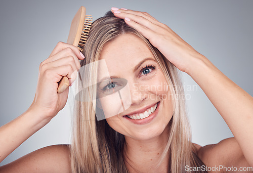 Image of Portrait, comb or woman with hair care, shine or salon treatment with girl on grey studio background. Face, female or lady brushing scalp, luxury or grooming routine for texture or volume on backdrop