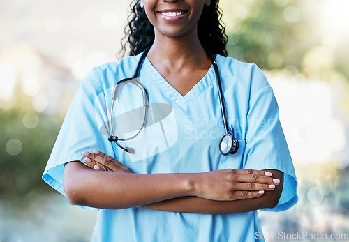 Image of Healthcare, crossed arms and African female doctor with stethoscope standing in a garden in nature. Happy, smile and professional black woman medical worker in a medicare hospital after consultation.