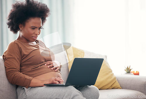 Image of Pregnancy, laptop and black woman on a sofa working from home on a freelance business project. Confused, computer and African pregnant female freelancer planning report while relaxing in living room.