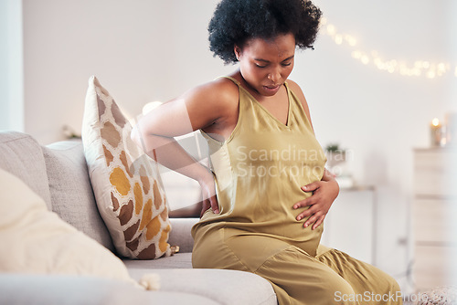 Image of Back pain, spine and pregnant woman with healthcare stress, problem or risk on sofa in her living room. Backache, stomach and pregnancy mother with medical emergency worry, labor or sick on her couch