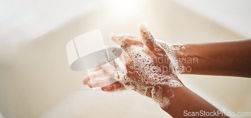 Image of Washing hands, soap and water for cleaning, hygiene and wellness in bathroom lens flare. Liquid, hand or skin care for bacteria, germs or virus protection in sink for healthcare and safety background