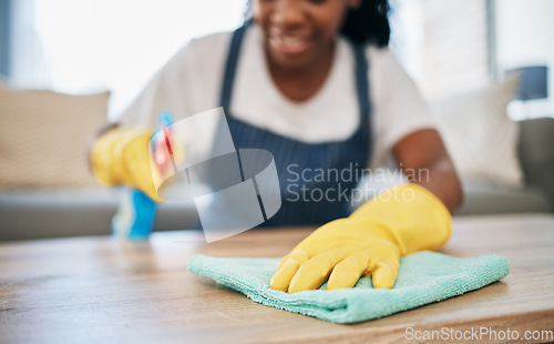 Image of Hand, cloth and gloves with a black woman cleaning a home for hygiene as a housekeeper or maid. Furniture, bacteria and chemical with a female cleaner working in housekeeping in an apartment