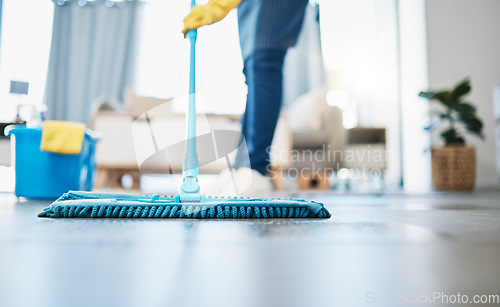 Image of Housekeeping, cleaning and woman maid with a mop to clean the living room floor at a house. Female domestic worker, cleaner and housewife washing the ground for bacteria, dust or dirt in her home.