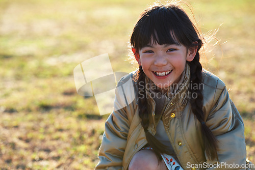 Image of Portrait, Asian girl and playing in park, smile and carefree on holiday, summer and freedom. Young person, female child and kid with happiness, play game or on field for fun, relax and break on grass