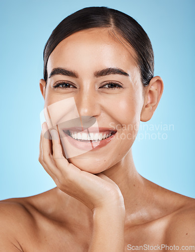 Image of Wellness, portrait and woman in a studio with a skincare, facial and natural beauty routine. Health, self care and happy female model with a cosmetic face or skin treatment by a blue background.