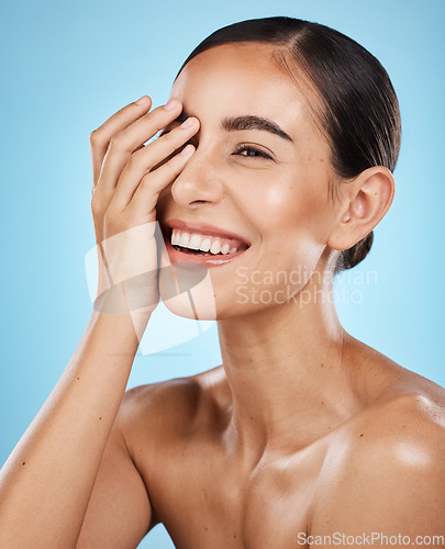 Image of Skincare, wellness and happy woman in a studio for a cosmetic, health and natural face routine. Self care, happiness and excited female model with a facial skin treatment isolated by blue background.