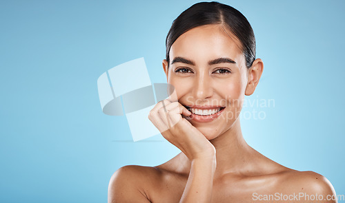 Image of Skincare, beauty and portrait of a woman in a studio with a cosmetic, facial and natural routine. Health, wellness and happy female model with a skin treatment by a blue background with mockup space.