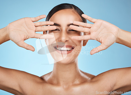 Image of Face, hands and beauty skincare of woman in studio isolated on a blue background. Portrait, makeup and cosmetics of female model with healthy, glowing and flawless skin after spa facial treatment.