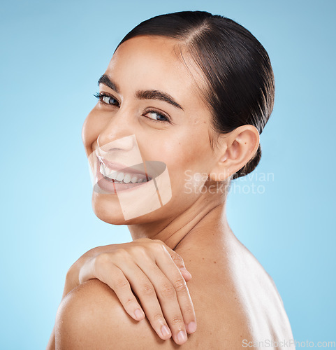 Image of Skincare, self care and portrait of a model in a studio for beauty, cosmetic and facial treatment. Cosmetics, happy and woman from Brazil with a healthy face routine isolated by a blue background.