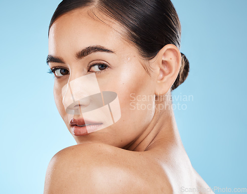 Image of Portrait, beauty and shoulder with a model woman in studio on a blue background for natural skincare. Face, skin and cosmetics with an attractive young female posing to promote a luxury product