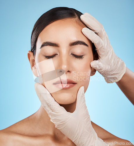 Image of Cosmetics, plastic surgery and hands check woman face for laser, botox implant or beauty salon. Skincare consultation, facial or gloves for aesthetic change, liposuction and filler on blue background