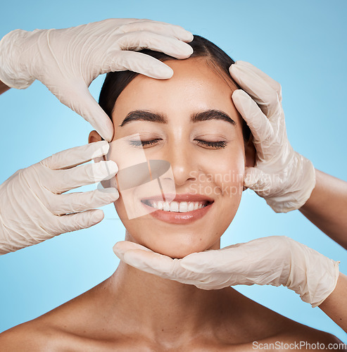 Image of Plastic surgery, beauty and woman in a studio for a skincare, natural and cosmetic facial treatment. Cosmetics, self love and surgeon hands on a female model face for consultation by blue background.