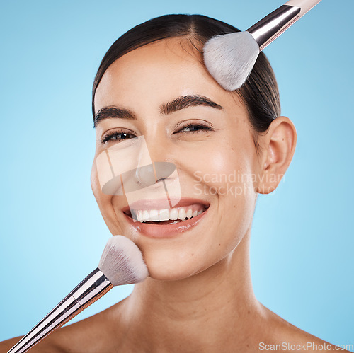 Image of Face portrait, beauty and makeup brush of woman in studio isolated on blue background. Aesthetics, facial treatment or skincare of happy female model with brushes for foundation, powder or cosmetics.
