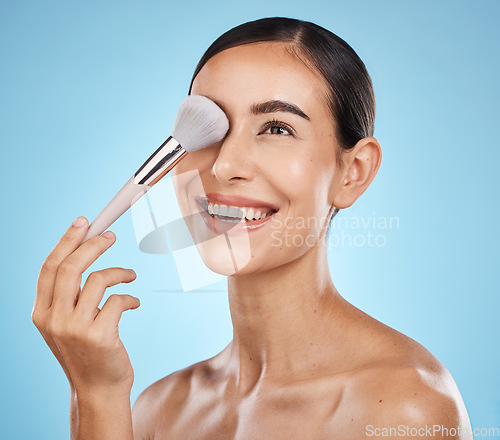 Image of Face, beauty and makeup brush of woman in studio isolated on a blue background. Thinking, facial treatment and skincare aesthetic of happy female model with tools for foundation, powder or cosmetics