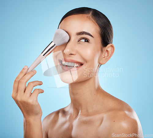 Image of Beauty, face and makeup brush of woman in studio isolated on a blue background. Thinking, facial treatment and skincare aesthetic of happy female model with tools for foundation, powder or cosmetics