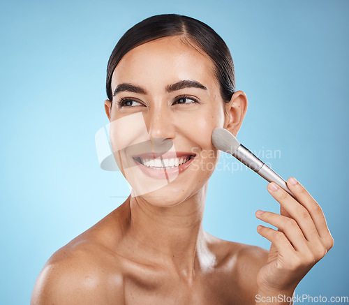 Image of Cosmetics, happy and woman with a brush for makeup isolated on a blue background in a studio. Skincare, beauty and model thinking of cosmetology, foundation and body health on a backdrop with a smile