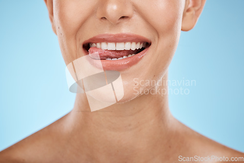 Image of Dental, health and woman with a smile in a studio for hygiene, wellness and natural oral routine. Healthy, veneers and closeup of female model with clean, beautiful and white teeth by blue background