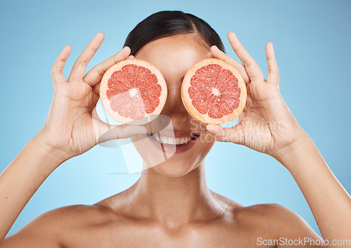 Image of Skin care, grapefruit and beauty woman fruit face for dermatology, cosmetics and wellness. Aesthetic model for natural sustainable facial glow, nutrition diet and healthy smile on blue background