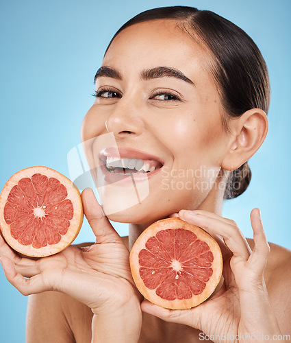 Image of Face, skincare and portrait of woman with grapefruit in studio isolated on a blue background. Organic cosmetics, food and female model with fruits for nutrition, healthy diet or vitamin c for beauty.