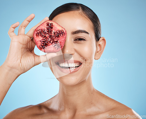 Image of Beauty, skin care and woman portrait with pomegranate fruit face for dermatology and cosmetics. Aesthetic model person for natural product facial glow, nutrition and healthy smile on blue background