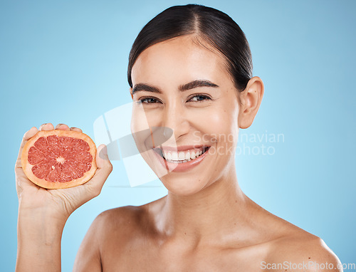 Image of Beauty, face and grapefruit squeeze woman portrait for dermatology, natural cosmetic and wellness. Aesthetic model person for sustainable facial glow, nutrition diet and skin care blue background
