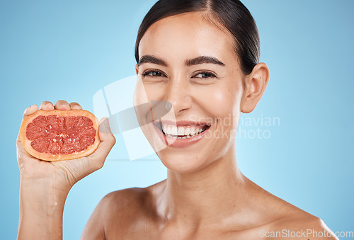 Image of Skin care, beauty and grapefruit squeeze woman portrait for dermatology, natural cosmetic and wellness. Face of aesthetic model for fruit glow facial, nutrition diet and healthy smile blue background