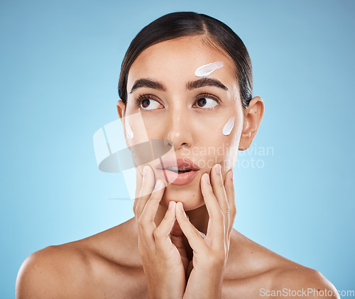 Image of Beauty cream, skin care and face of a woman with hands for dermatology, cosmetics and natural glow. Aesthetic model person with secret spa facial lotion for health and wellness on a blue background