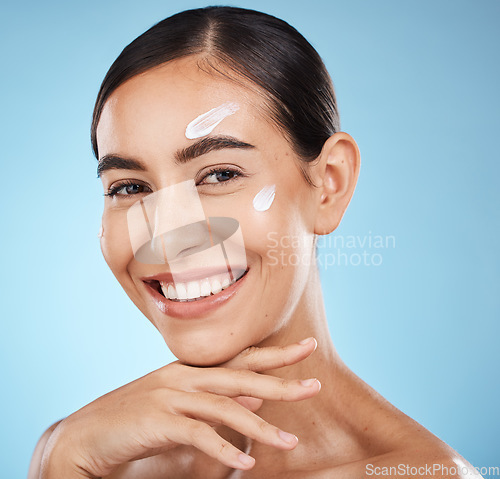 Image of Skincare portrait, face cream and woman in studio isolated on a blue background. Cosmetics, dermatology and happy female model with lotion, creme or moisturizer for beauty, aesthetics and wellness.