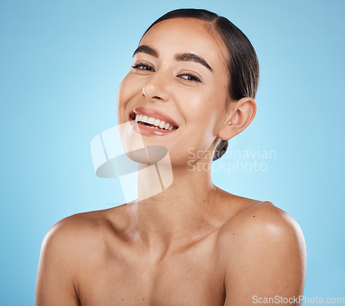 Image of Portrait, beauty and skin with a model woman in studio on a blue background for natural treatment. Face, skincare and cosmetics with an attractive young female posing to promote a luxury product