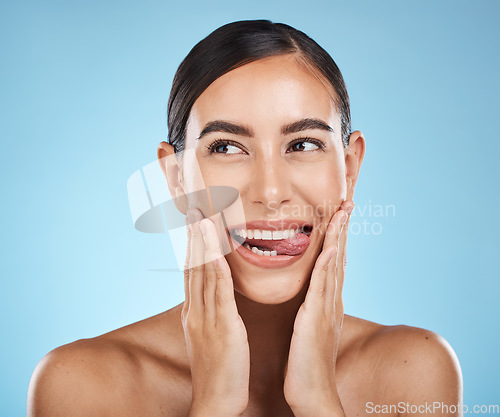 Image of Face, tongue out and beauty skincare of woman in studio isolated on a blue background. Thinking, makeup or cosmetics of female model with healthy, glowing and flawless skin after spa facial treatment