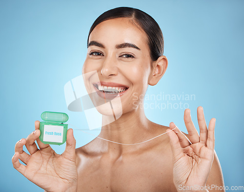 Image of Woman, floss and smile in portrait with dental healthcare, fresh breath and teeth cleaning isolated on blue background. Face, happy and oral hygiene product, mouth health with healthy gums in studio