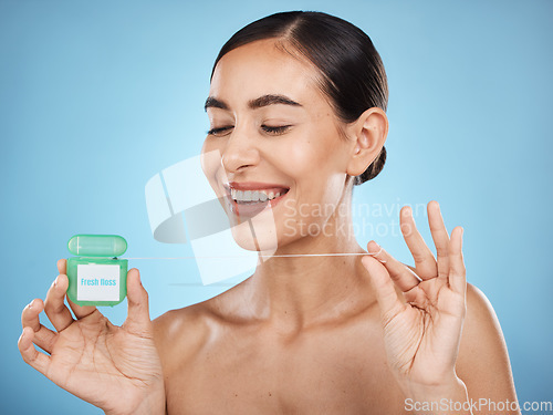 Image of Woman, floss and smile, face with dental healthcare, fresh breath and teeth cleaning isolated on blue background. Happy flossing, oral hygiene product and mouth health with healthy gums in studio