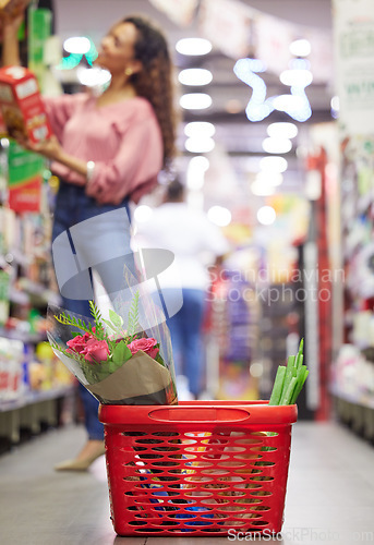 Image of Shop floor aisle, grocery basket with flowers, black woman or box for choice, sale or discount in valentines promotion. Young african female, low angle and groceries shelf for product deal in store