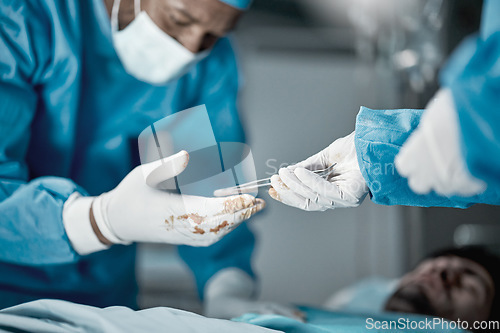 Image of Hospital, surgery and hands of doctors with tweezers in operating room for emergency operation on patient. Health clinic, teamwork and medical surgeons working with surgical tools to save life of man