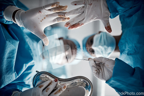 Image of Doctors, surgery and blood hands in hospital theater with surgeon team for emergency, teamwork and trust. Medical man and woman with glove for life saving, healthcare and health insurance emergency