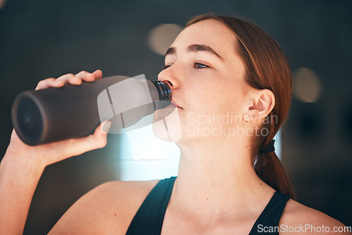 Image of Fitness, hydration and female athlete drinking water for thirst, wellness and health in a training studio. Sports, energy and young woman enjoying a healthy cold beverage after a workout or exercise.
