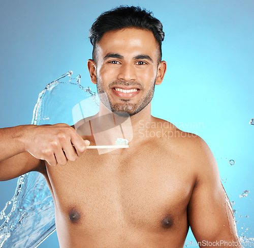 Image of Portrait, water and man with toothbrush, toothpaste and dental hygiene on blue studio background. Male, gentleman and oral health for clean mouth, smile and fresh breath with healthy gums on backdrop